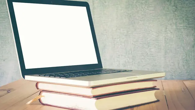 [Translate to English:] Buch mit Laptop